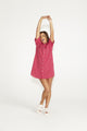 A woman wearing a pink dress, showcasing trendy styles from an online fashion boutique.